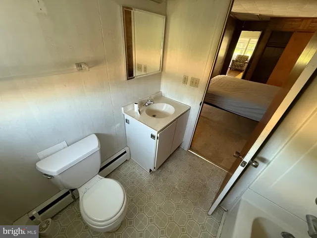 a bathroom with a toilet sink and mirror