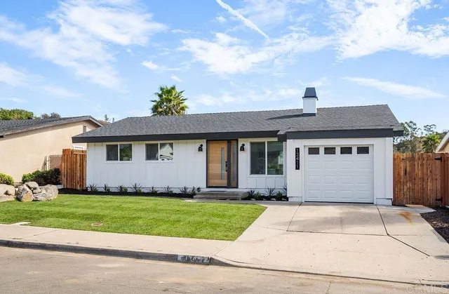a front view of a house with a garden and plants