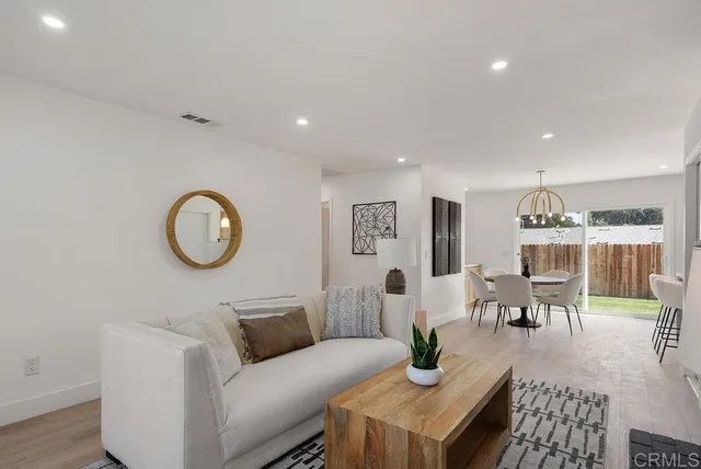 a living room with furniture kitchen view and a window