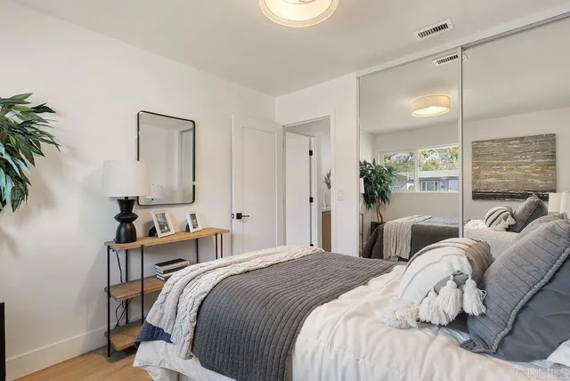 a bedroom with a bed and a potted plant