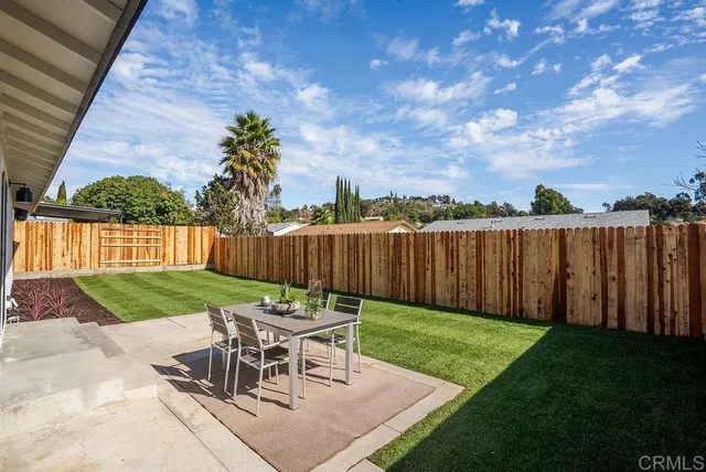 a view of a chairs and table in backyard