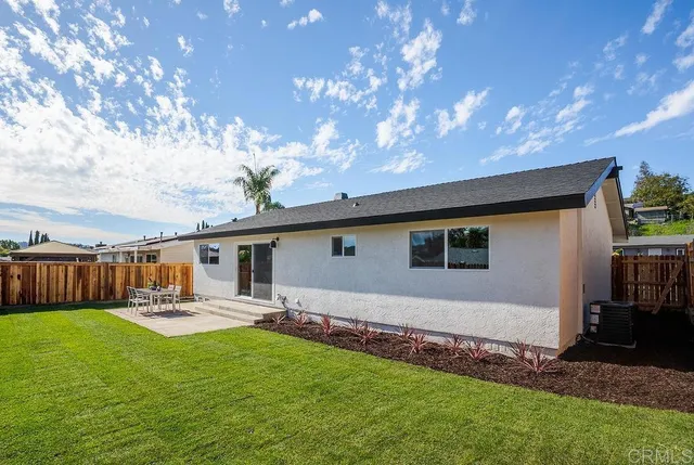 a backyard of a house with table and chairs