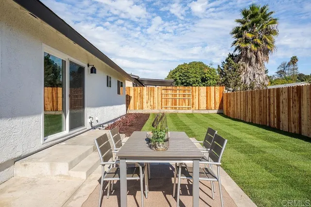 a view of an house with backyard and furniture