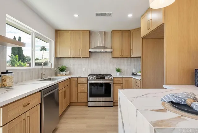 a kitchen with stainless steel appliances granite countertop a sink and cabinets