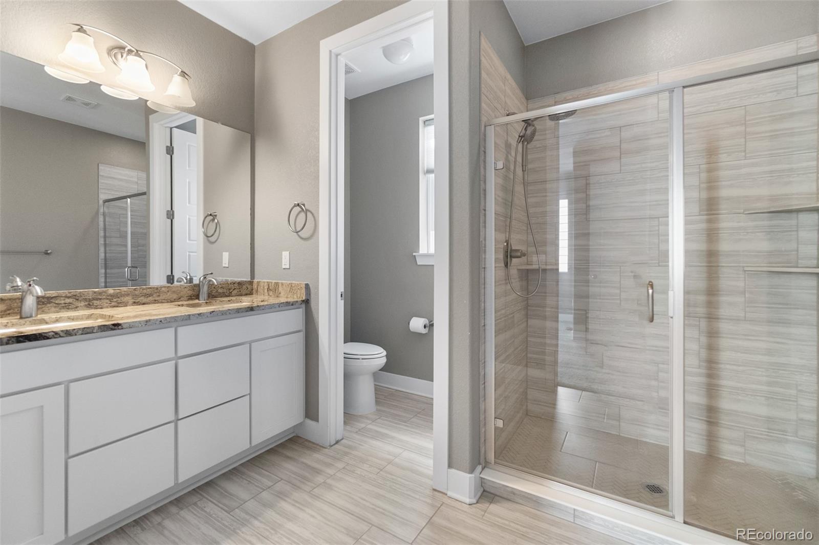 11918 Mountview Lane Broomfield, CO 80021 - Photo 23 of 32 a bathroom with a double vanity sink toilet and shower