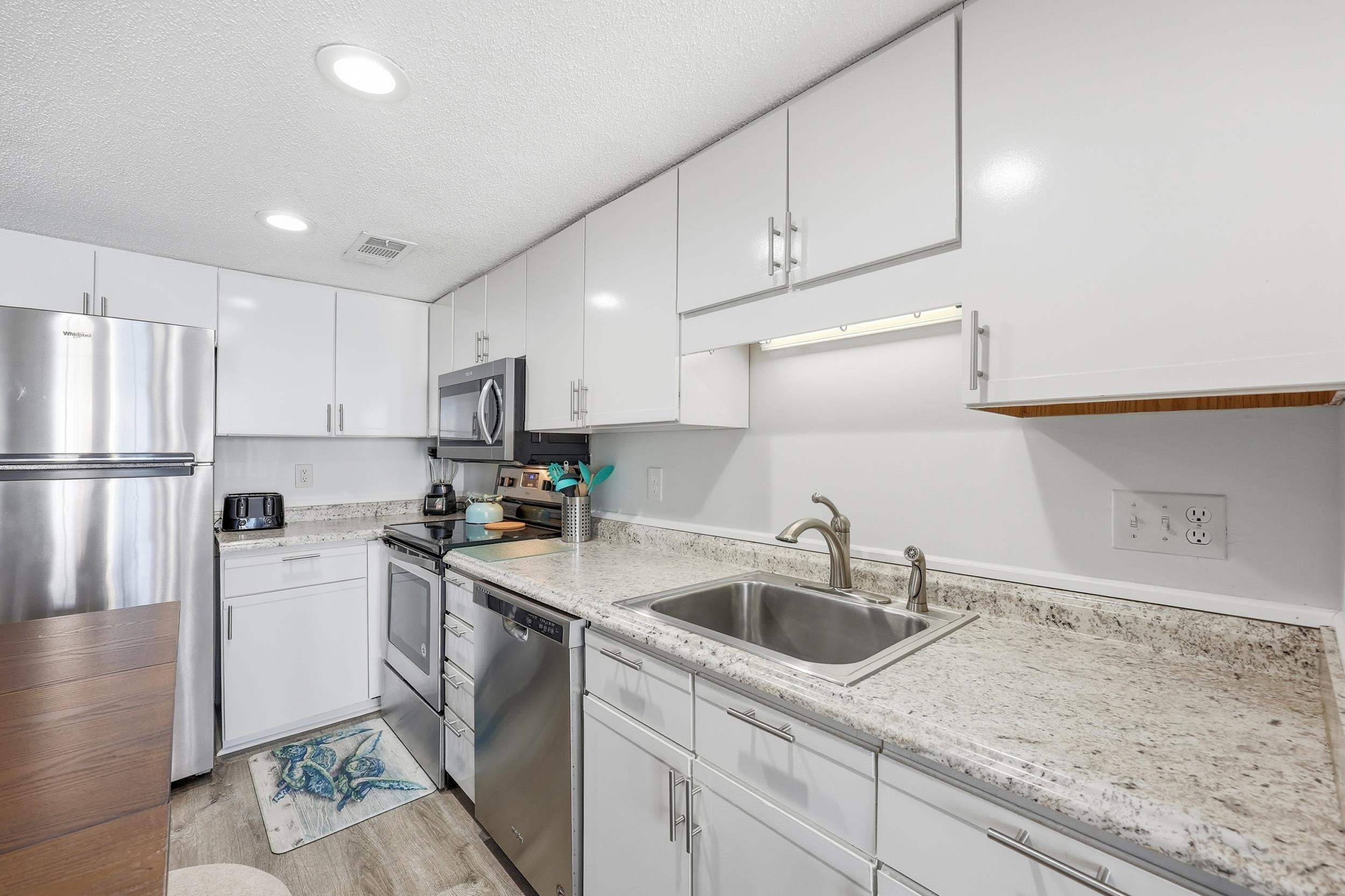 920 North Waccamaw Drive, Unit 2305 Murrells Inlet, SC 29576 - Photo 15 of 40 Kitchen featuring appliances with stainless steel finishes, a textured ceiling, white cabinetry, recessed lighting, and light wood finished floors