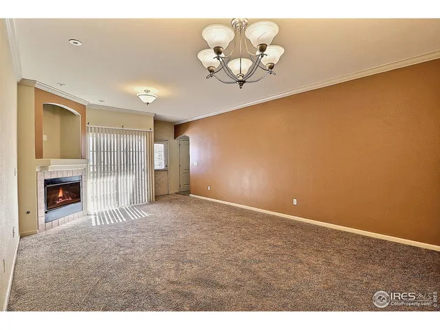 a view of a room with a chandelier fan and a window