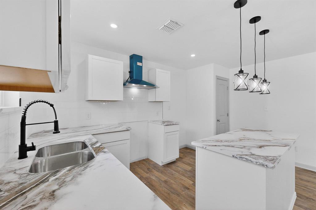 5650 Forney Road Dallas, TX 75227 - Photo 14 of 39 a kitchen with a sink cabinets and wooden floor