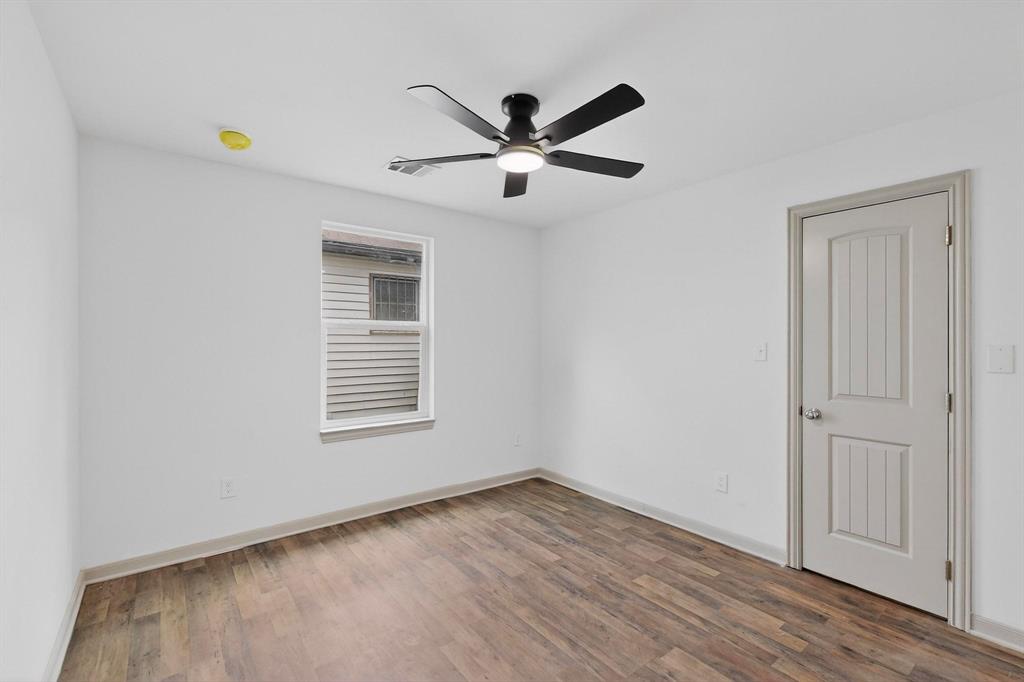 5650 Forney Road Dallas, TX 75227 - Photo 31 of 39 a view of empty room with wooden floor and ceiling fan