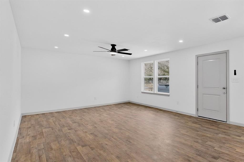 5650 Forney Road Dallas, TX 75227 - Photo 5 of 39 a view of an empty room with wooden floor and a window
