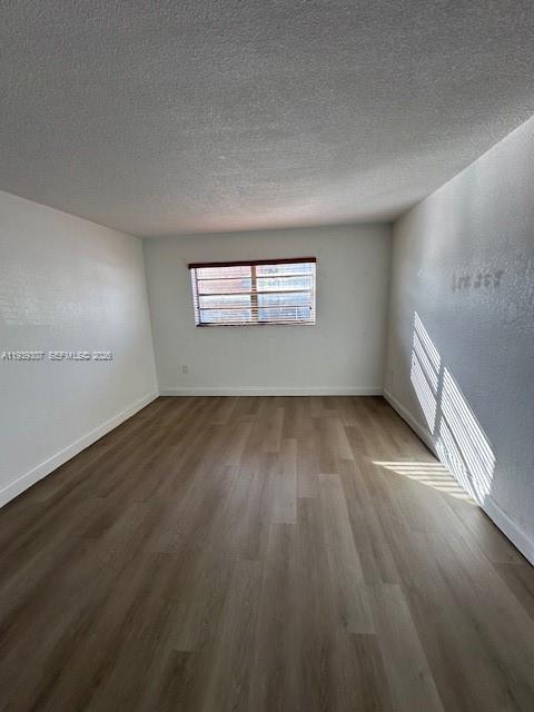 1015 Northwest 45th Avenue, Unit 101 Miami, FL 33126 - Photo 6 of 17 an empty room with wooden floor and windows
