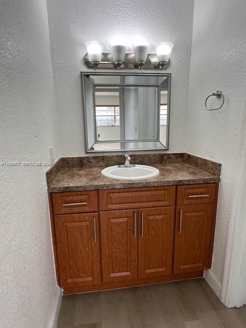 1015 Northwest 45th Avenue, Unit 101 Miami, FL 33126 - Photo 9 of 17 a bathroom with a granite countertop sink a light fixture and a mirror