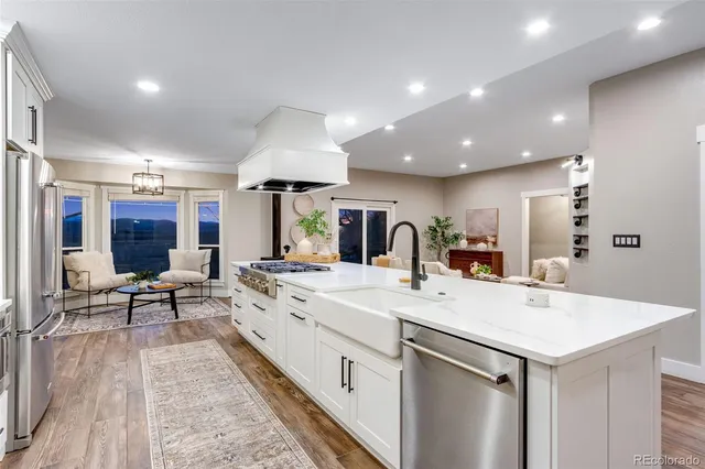 a kitchen with stainless steel appliances kitchen island granite countertop a stove a sink and a refrigerator