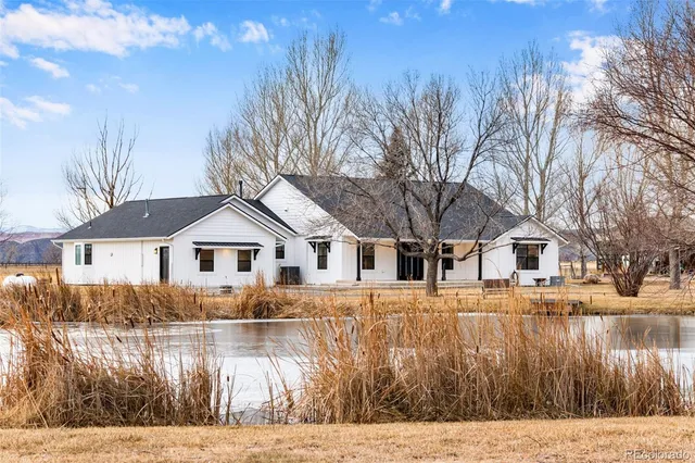 a front view of a house with a yard covered with trees
