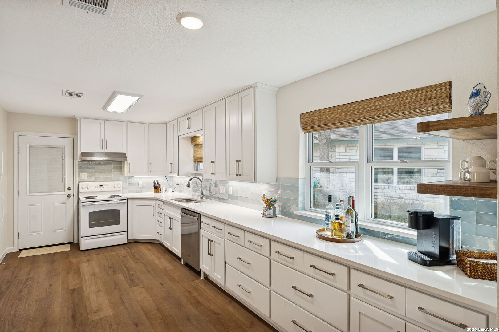 119 Robin Road Highland Haven, TX 78654 - Photo 15 of 33 a kitchen with a sink dishwasher stove and white cabinets