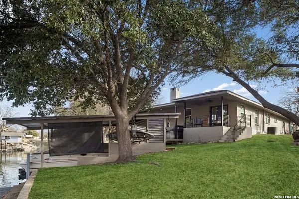 a view of a house with backyard and a tree