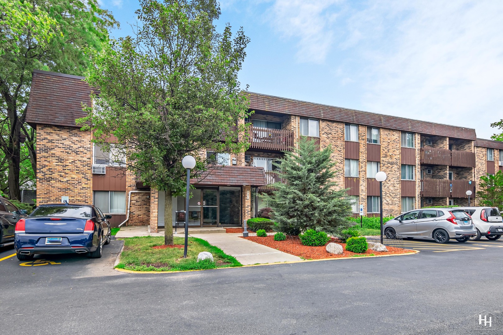 940 East Old Willow Road, Unit 206 Prospect Heights, IL 60070 - Photo 22 of 25 a car parked in front of a brick house next to a road