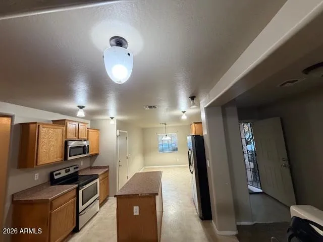 a kitchen with stainless steel appliances granite countertop a refrigerator and a stove top oven