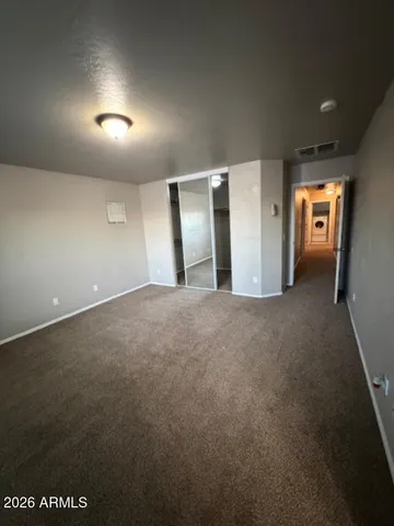 an empty room with closet and mirror