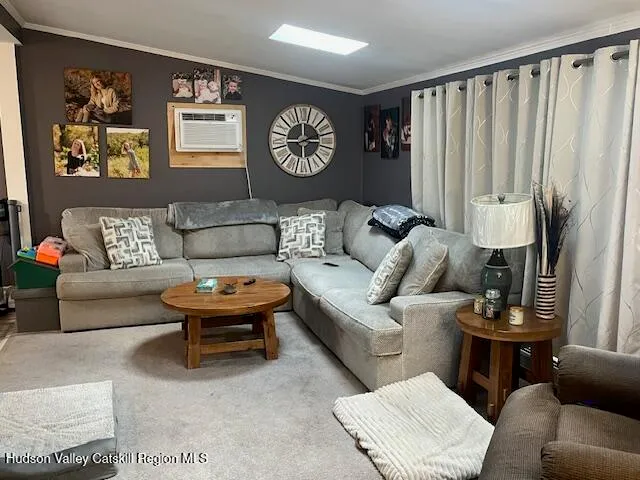 a living room with furniture a clock on wall and a window