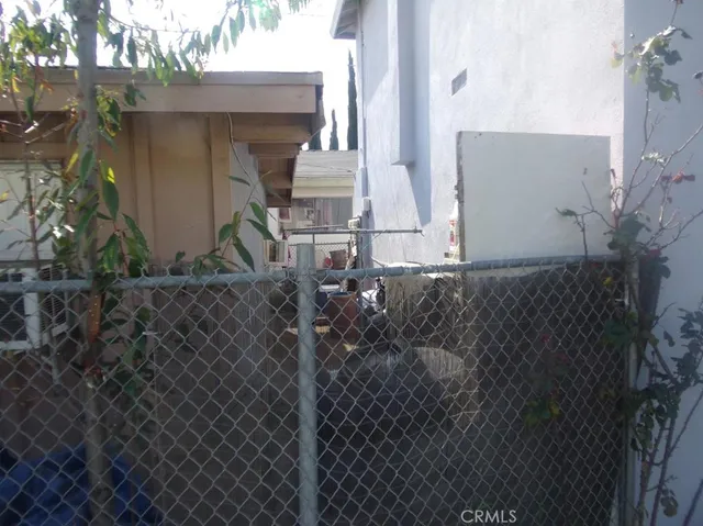 a view of a house with a small yard and large tree