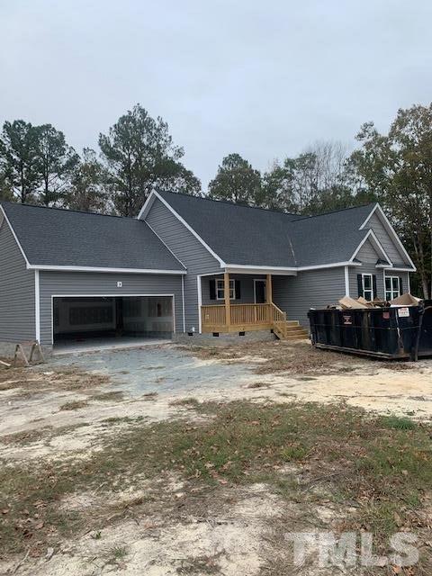a front view of house with yard and trees in the background