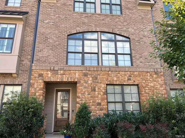 front view of a brick house with a small yard
