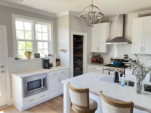 a kitchen with a table chairs stove and cabinets
