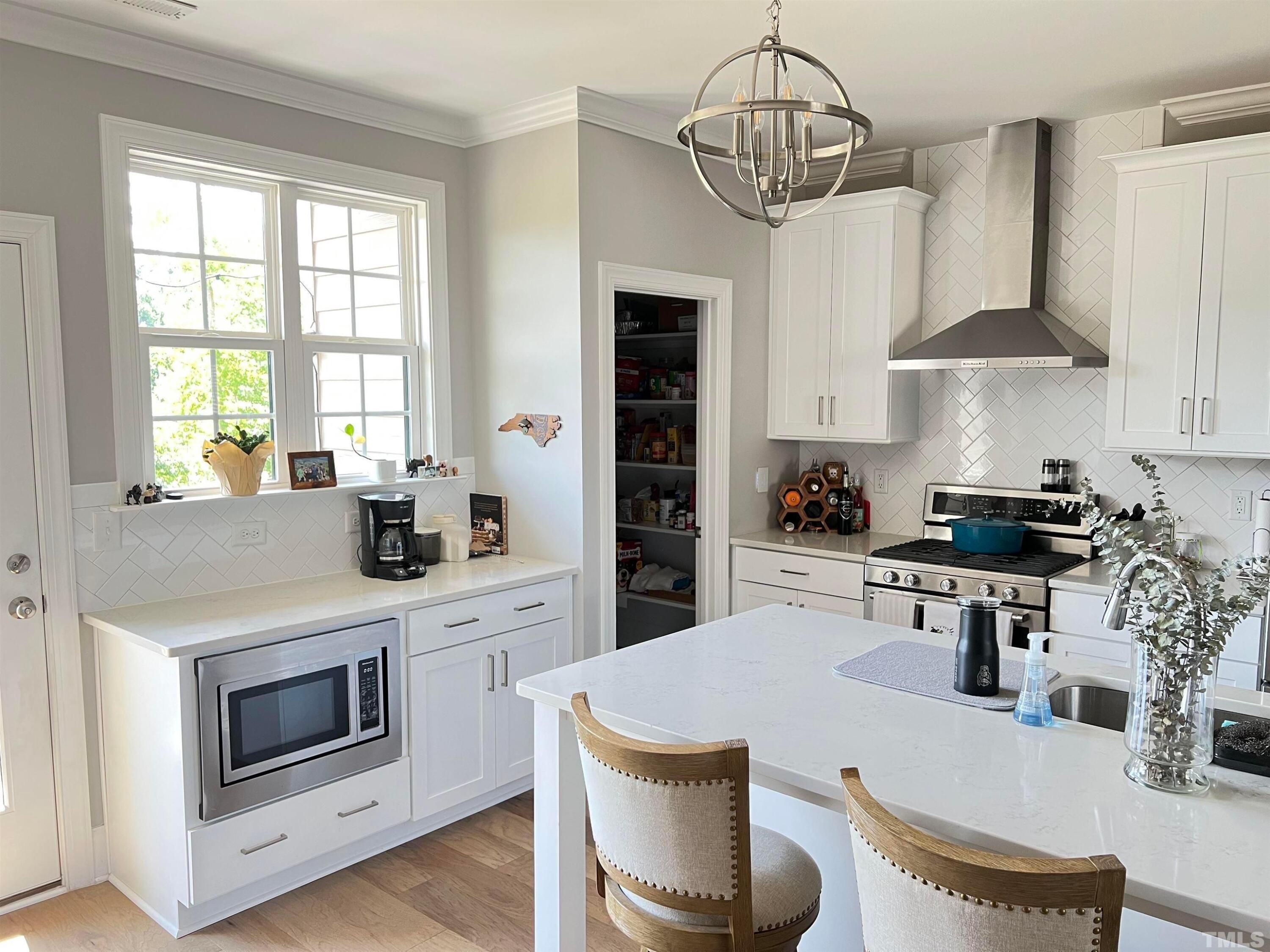 5807 Abingdon Ridge Place Raleigh, NC 27607 - Photo 5 of 24 a kitchen with a table chairs stove and cabinets