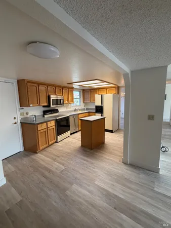 a large kitchen with stainless steel appliances granite countertop a stove and a sink