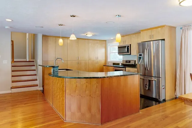 a kitchen with granite countertop a sink cabinets and stainless steel appliances
