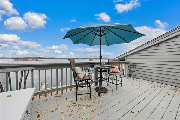 a view of a roof deck with table and chairs under an umbrella