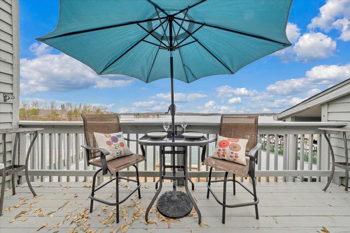 93 Peninsula Point Drive, Unit B5 Moneta, VA 24121 - Photo 2 of 48 a view of a patio with a table and chairs under an umbrella