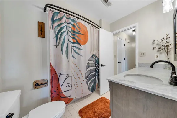 a bathroom with a granite countertop sink a toilet and mirror