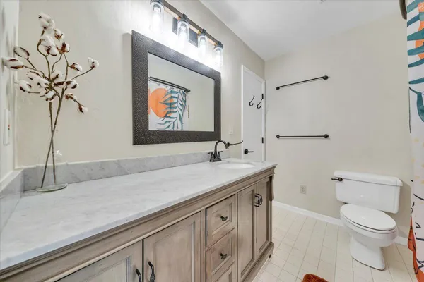 a bathroom with a sink and mirror with bathtub