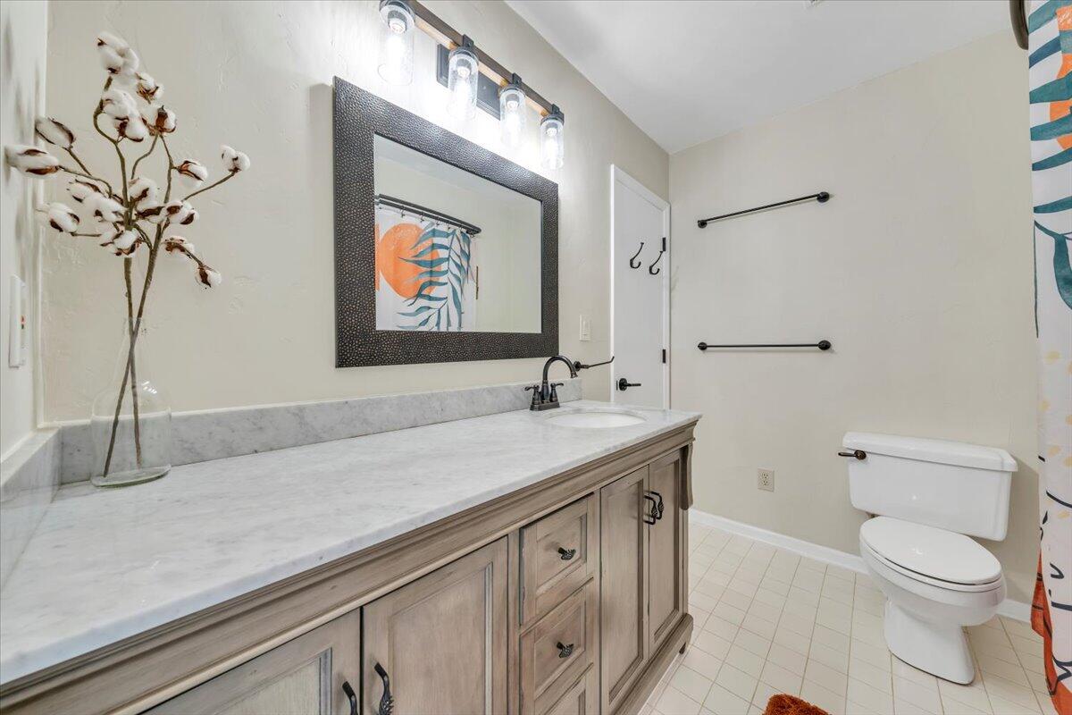 93 Peninsula Point Drive, Unit B5 Moneta, VA 24121 - Photo 27 of 48 a bathroom with a granite countertop sink a toilet and mirror