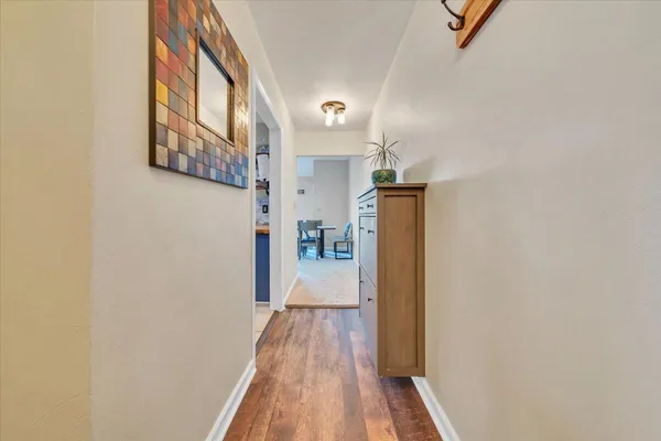 a view of a hallway with wooden floor and staircase