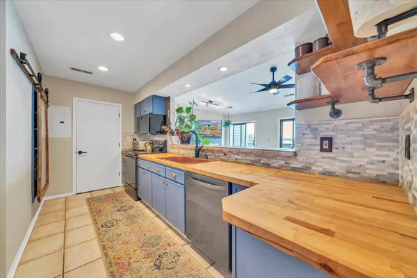 a large kitchen with kitchen island a sink stainless steel appliances and cabinets