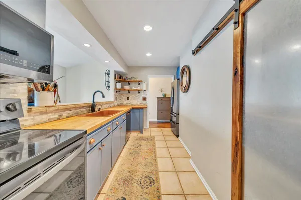 a large kitchen with stainless steel appliances granite countertop a sink and cabinets