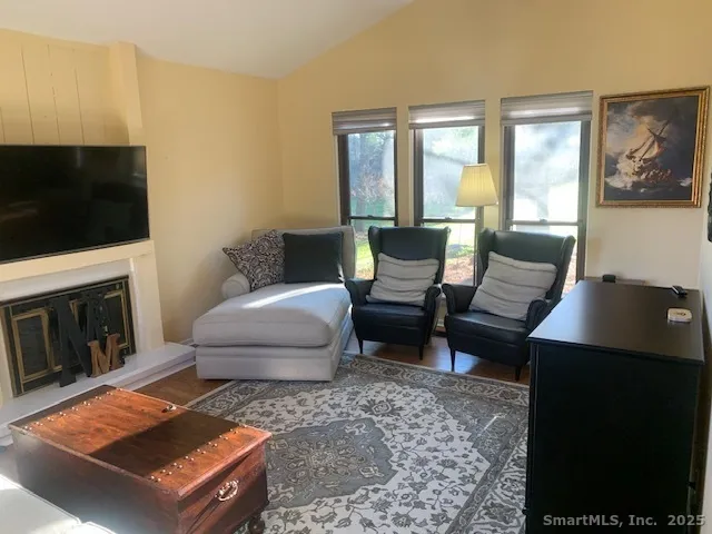 a living room with furniture a flat screen tv and a fireplace