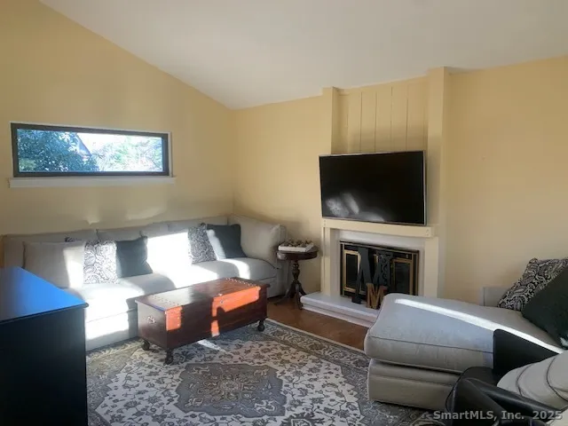 a living room with furniture a flat screen tv and a fireplace