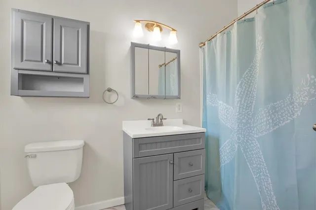 a bathroom with a toilet a sink and a mirror