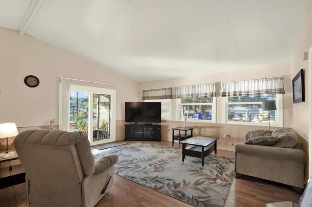 a living room with furniture a flat screen tv and a large window