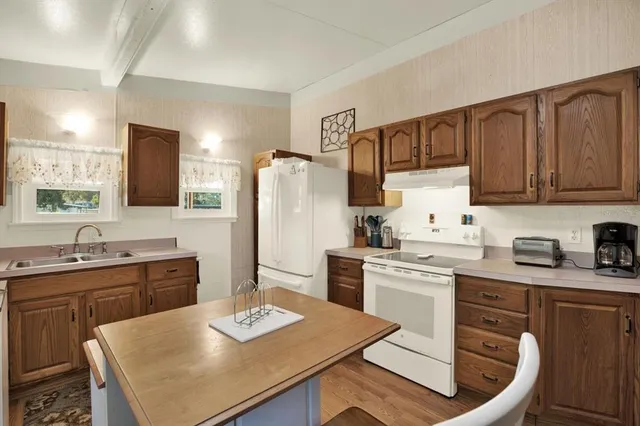 a kitchen with a sink a stove a refrigerator and white cabinets