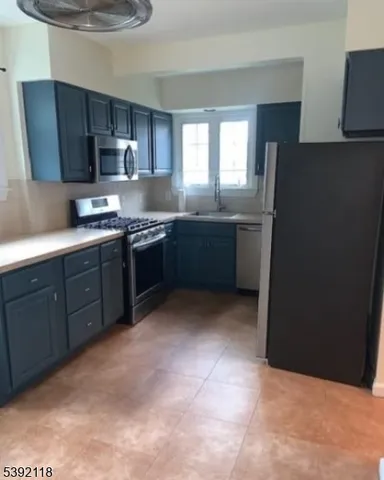 a kitchen with stainless steel appliances granite countertop a refrigerator a stove a sink and dishwasher