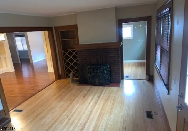 a view of a livingroom with wooden floor and a fireplace