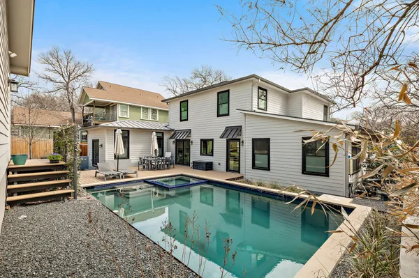 a view of a house with pool and chairs