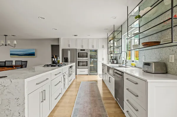 a large kitchen with stainless steel appliances granite countertop a sink and cabinets