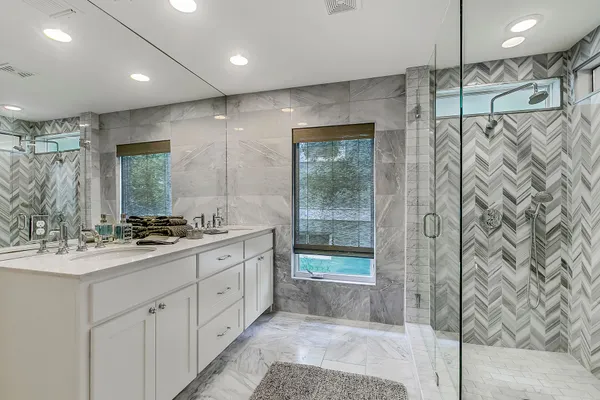 a bathroom with a double vanity sink mirror and shower