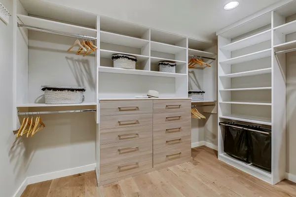 a view of walk in closet with clothes and shoes
